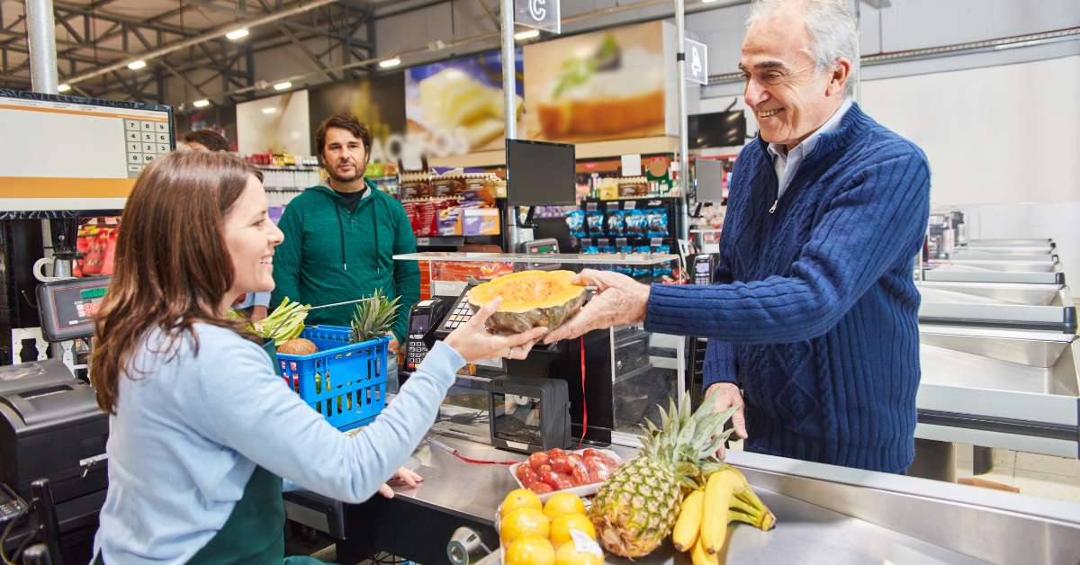 A woman purchases an item from a store associate using an identity based discount showcasing her loyalty and the company's improved marketing strategy.
