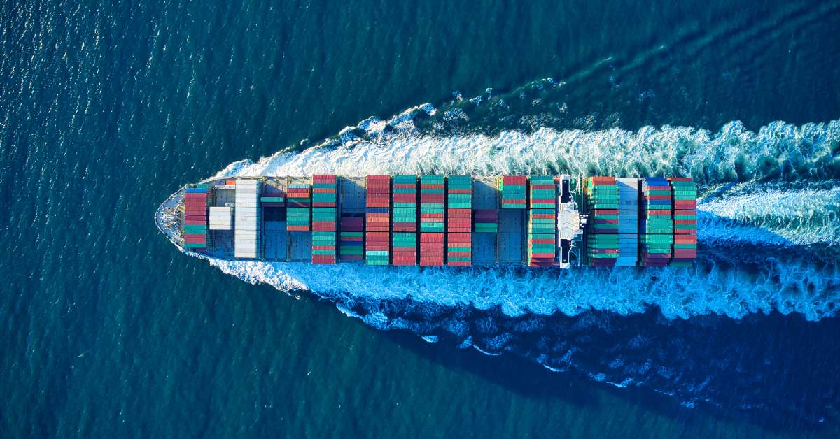 Image of cargo ship full of supply chain cargo sailing across the ocean.